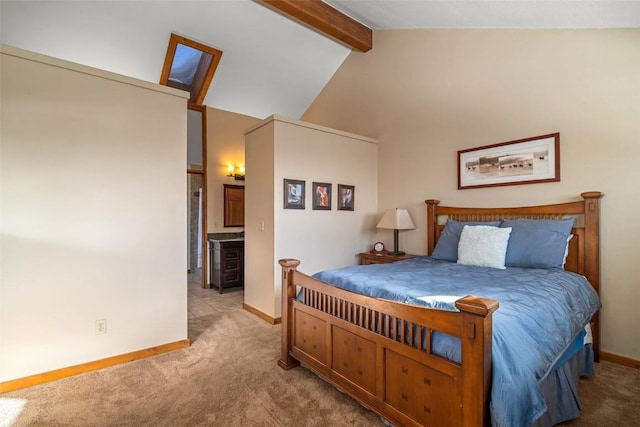 carpeted bedroom featuring ensuite bath and lofted ceiling with beams