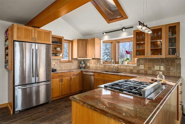 kitchen featuring sink, dark stone counters, hanging light fixtures, kitchen peninsula, and stainless steel appliances