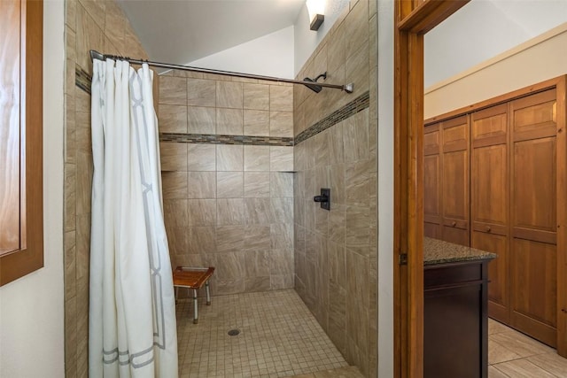 bathroom featuring tile patterned flooring, curtained shower, and lofted ceiling