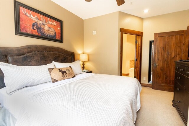 bedroom featuring ceiling fan, light carpet, and connected bathroom