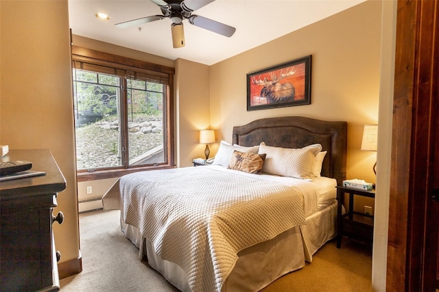 bedroom featuring multiple windows, ceiling fan, light colored carpet, and a baseboard heating unit