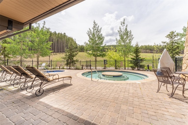 view of swimming pool with a patio and a hot tub