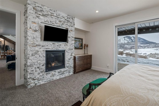 bedroom featuring access to exterior, recessed lighting, carpet flooring, a stone fireplace, and baseboards