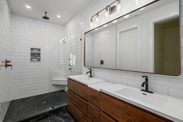 bathroom featuring vanity, decorative backsplash, walk in shower, and tile walls