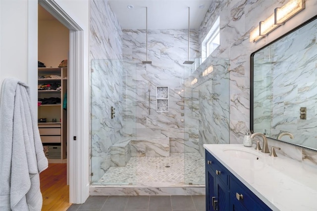 bathroom featuring vanity, tile patterned flooring, and tiled shower