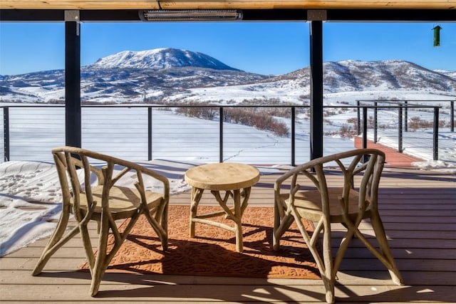 snow covered back of property featuring a mountain view