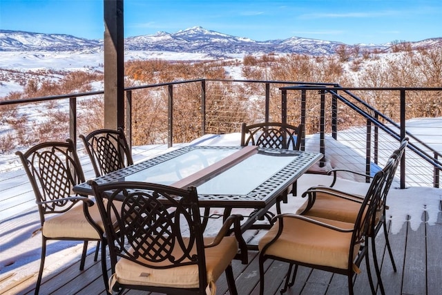 snow covered back of property featuring a mountain view