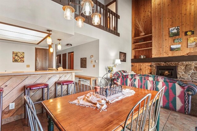 dining room featuring built in shelves, wood walls, and a fireplace