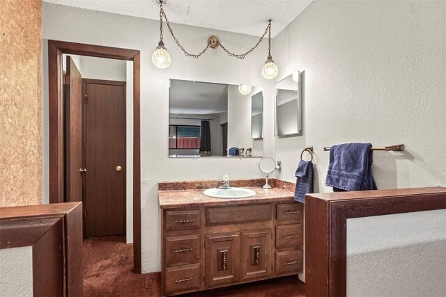 bathroom featuring a textured ceiling and vanity