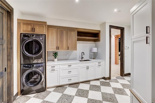 laundry room with sink, cabinets, and stacked washer and dryer