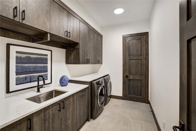 washroom with washer and dryer, sink, light tile patterned floors, and cabinets