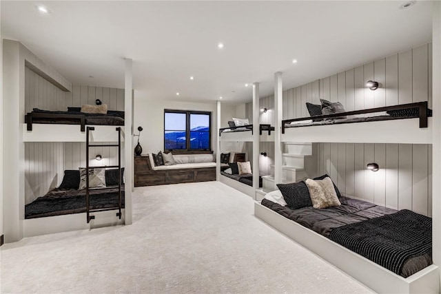 carpeted bedroom featuring wood walls