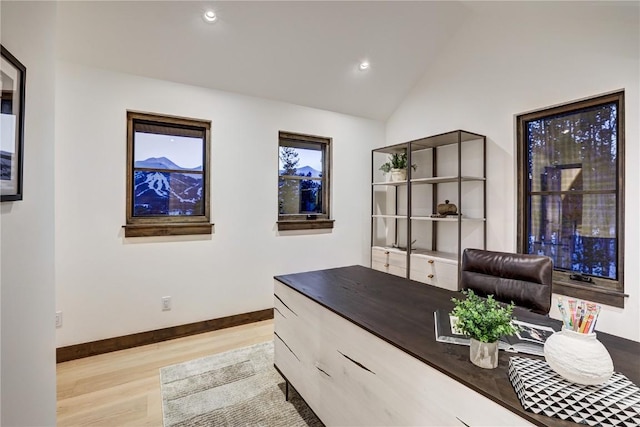 office area with light hardwood / wood-style floors and vaulted ceiling