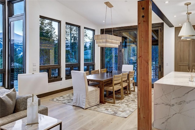 dining space featuring lofted ceiling and light hardwood / wood-style flooring