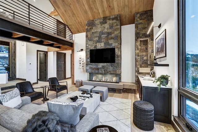 tiled living room featuring a stone fireplace, high vaulted ceiling, and wooden ceiling