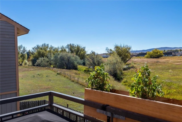 view of yard featuring a mountain view, a balcony, and a rural view