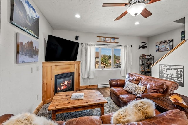 living room with ceiling fan, a baseboard radiator, a textured ceiling, and hardwood / wood-style flooring