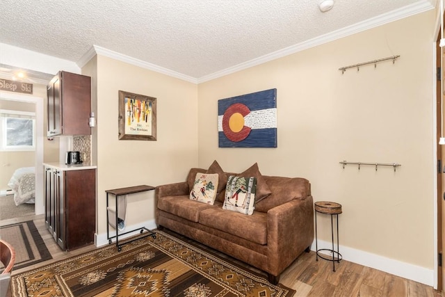 living room with hardwood / wood-style floors, a textured ceiling, and ornamental molding