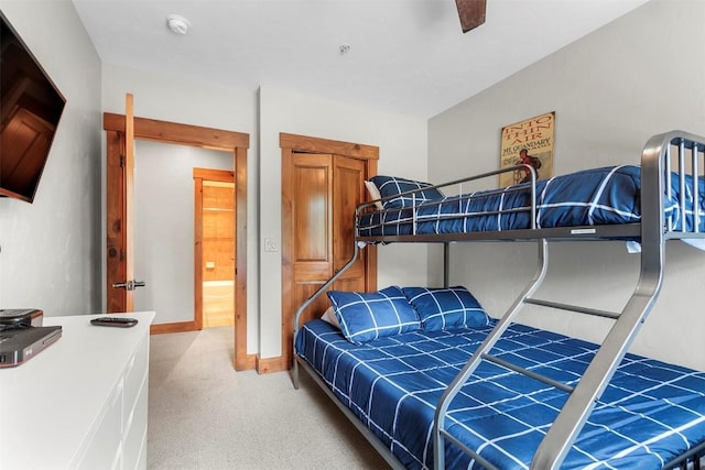 bedroom with baseboards and light colored carpet