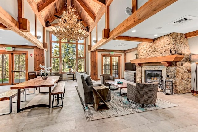 interior space with french doors, beamed ceiling, and a stone fireplace