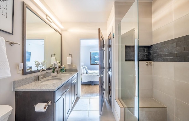 bathroom featuring tile patterned floors, vanity, toilet, and a shower with door