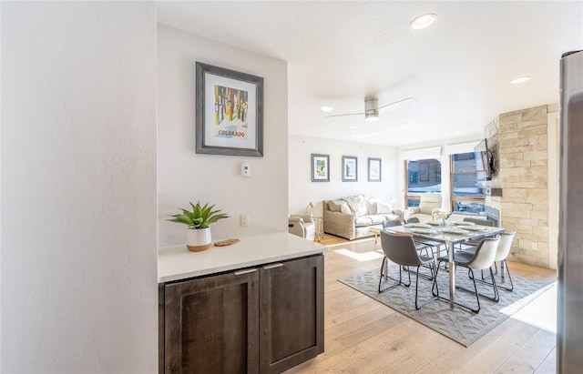 dining space with ceiling fan and light wood-type flooring