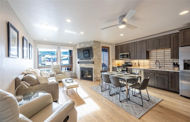 kitchen with light hardwood / wood-style flooring, sink, dark brown cabinets, and appliances with stainless steel finishes