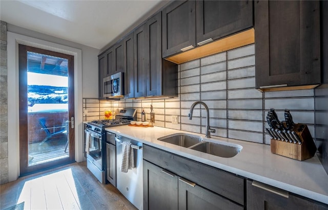 kitchen with sink, backsplash, light hardwood / wood-style floors, stainless steel appliances, and light stone countertops