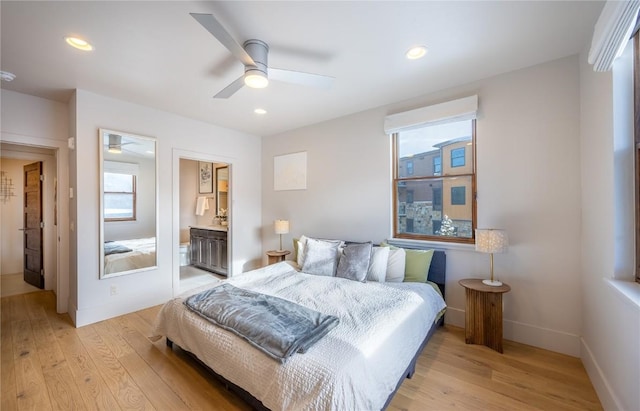 bedroom with ceiling fan, ensuite bathroom, and light hardwood / wood-style floors