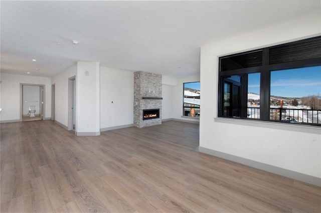 unfurnished living room featuring a fireplace and light hardwood / wood-style flooring