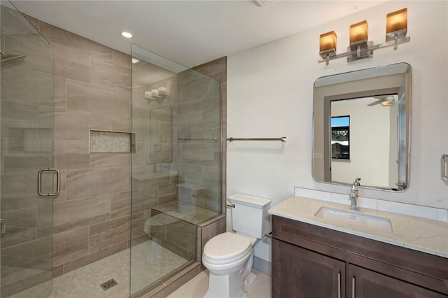 bathroom with tile patterned floors, vanity, toilet, and walk in shower