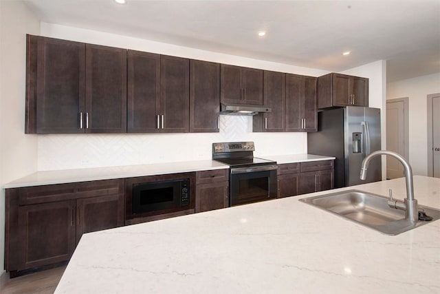 kitchen with backsplash, black appliances, sink, dark brown cabinets, and light stone counters