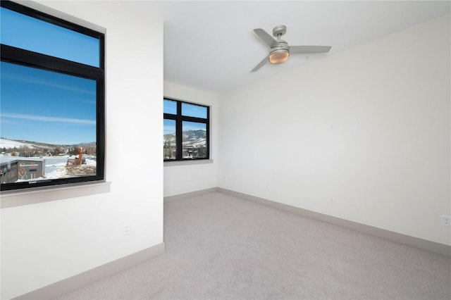 spare room with ceiling fan and light colored carpet