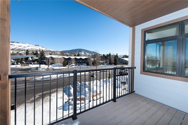 snow covered back of property with a mountain view