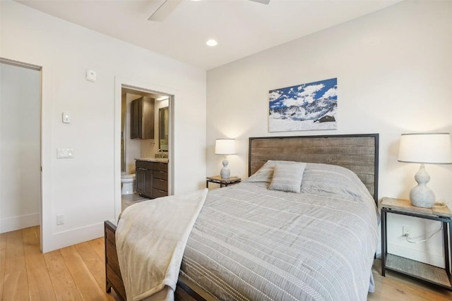 bedroom featuring connected bathroom, ceiling fan, light hardwood / wood-style flooring, and sink