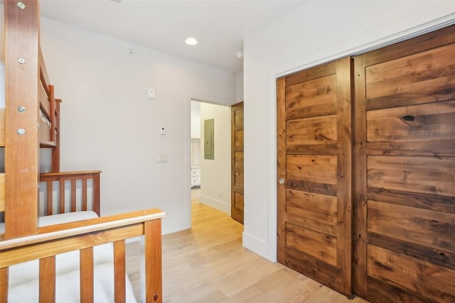 hall featuring electric panel and light hardwood / wood-style flooring