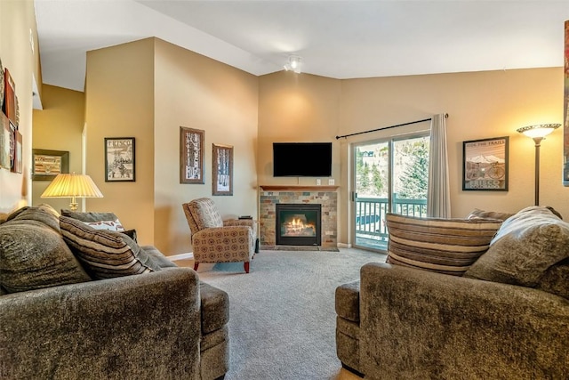 living area with carpet floors, lofted ceiling, and a tiled fireplace