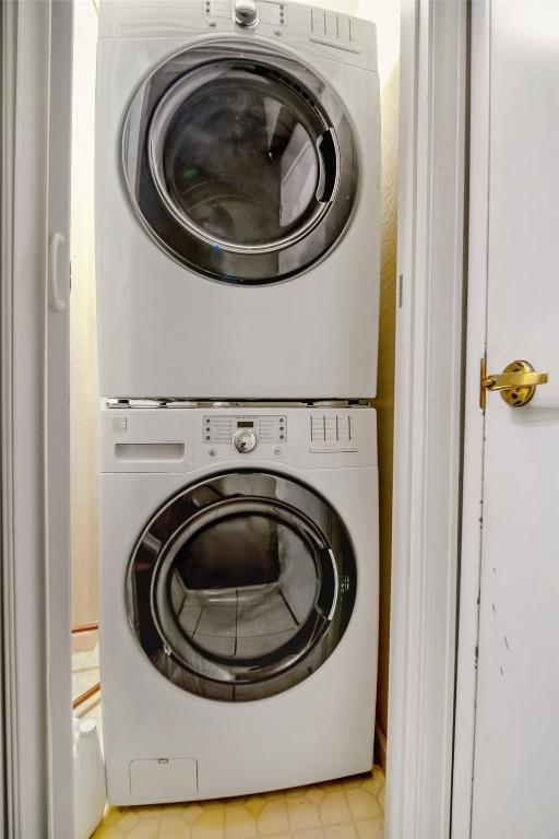 clothes washing area featuring laundry area and stacked washing maching and dryer