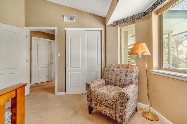 living area with vaulted ceiling, carpet floors, visible vents, and baseboards