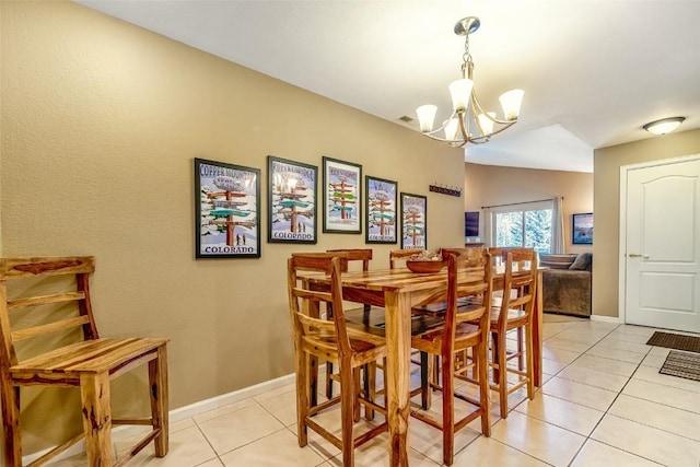 dining space with lofted ceiling, baseboards, an inviting chandelier, and light tile patterned floors