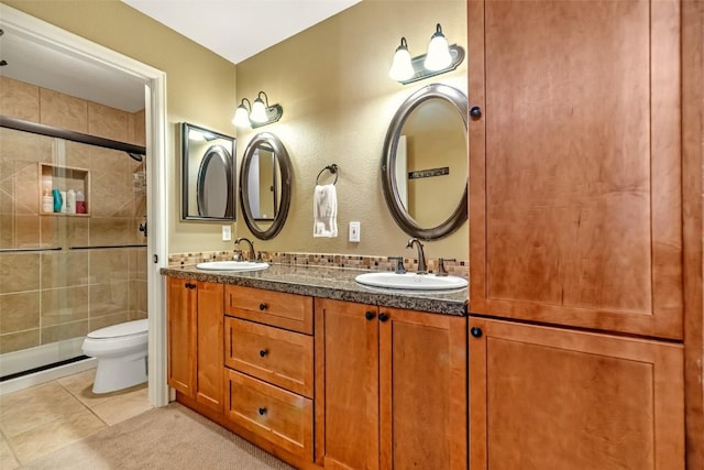 full bathroom with toilet, tile patterned flooring, a sink, and tiled shower