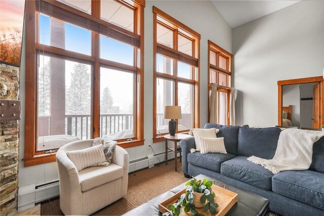 living room with a towering ceiling and baseboard heating