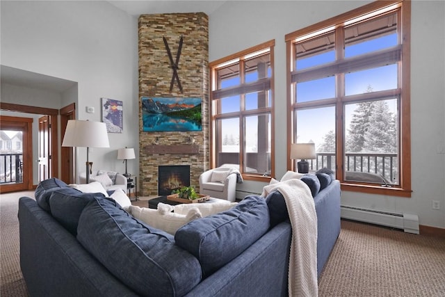 carpeted living room with a baseboard heating unit, a stone fireplace, a towering ceiling, and baseboards