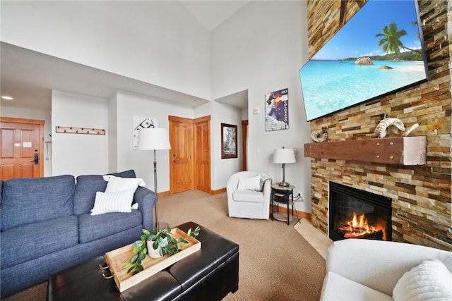 living area featuring high vaulted ceiling, a stone fireplace, carpet flooring, and baseboards