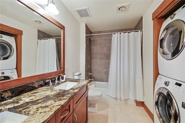 laundry room featuring light tile patterned flooring, laundry area, stacked washer / dryer, a sink, and visible vents