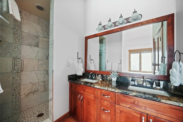 full bath featuring double vanity, a sink, and a shower stall