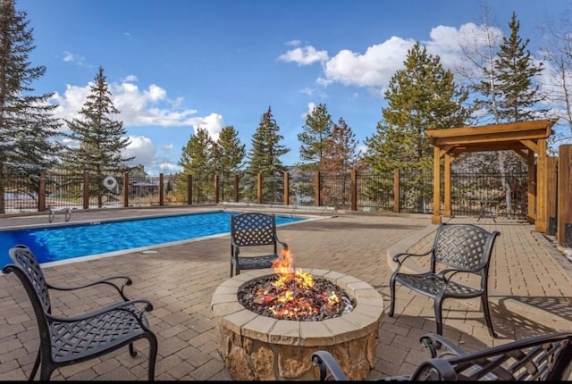 community pool featuring a patio area, a fire pit, and fence