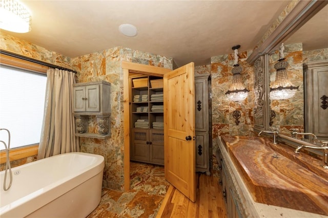 bathroom with a bathtub, plenty of natural light, and hardwood / wood-style floors