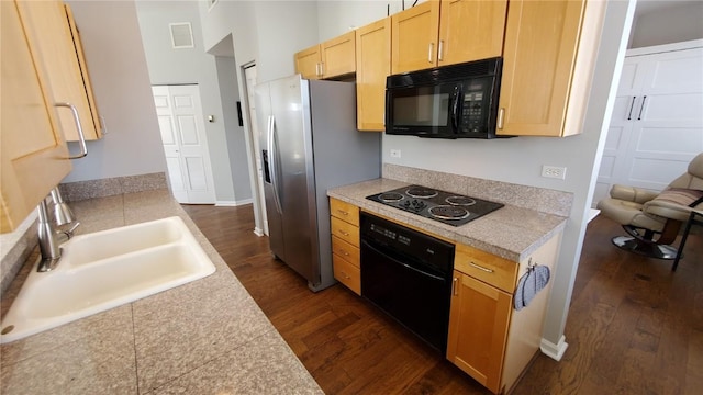 kitchen with tile counters, visible vents, a sink, and black appliances