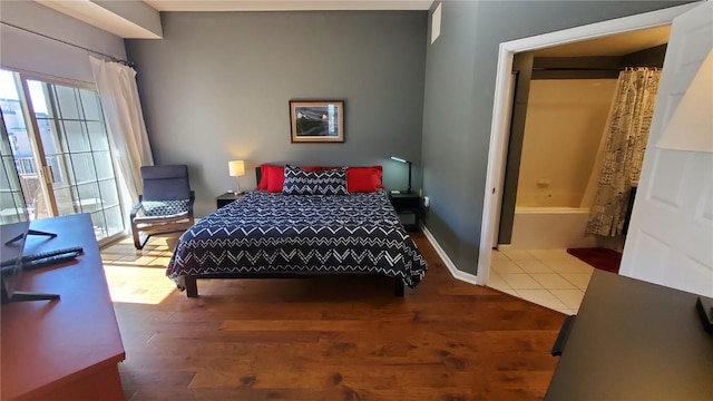 bedroom with baseboards and wood finished floors